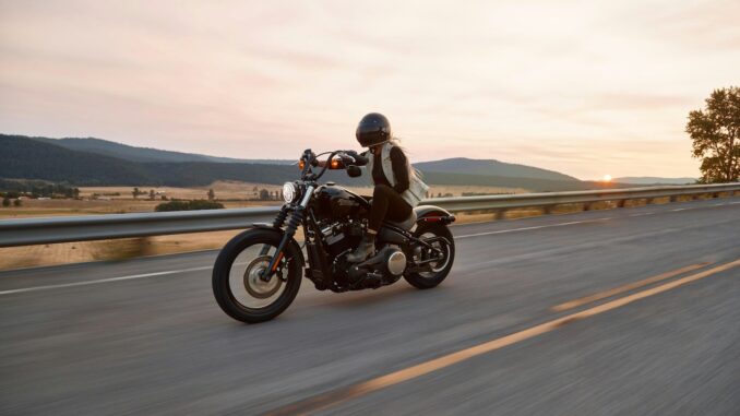 Photo by Harley-Davidson man on black cruiser motorcycle in highway